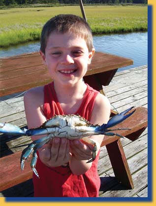 An image of a boy with a crab on the Inn's private dock